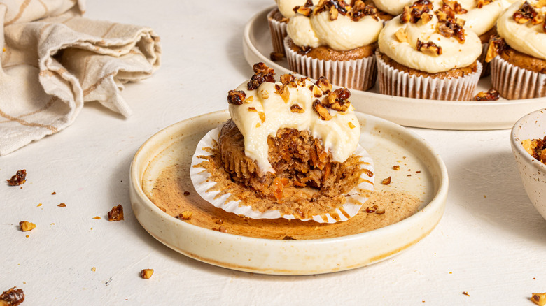 Carrot cake cupcakes with a bite off on a plate