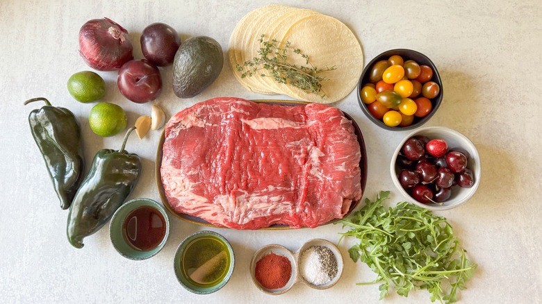 Grilled flank steak tacos with stone fruit salsa ingredients on countertop