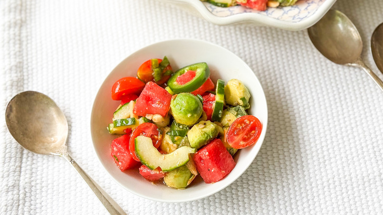 Deconstructed watermelon salad in bowl with spoons