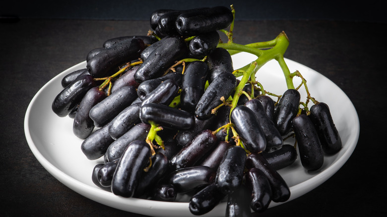 A plate full of black moon drop grapes