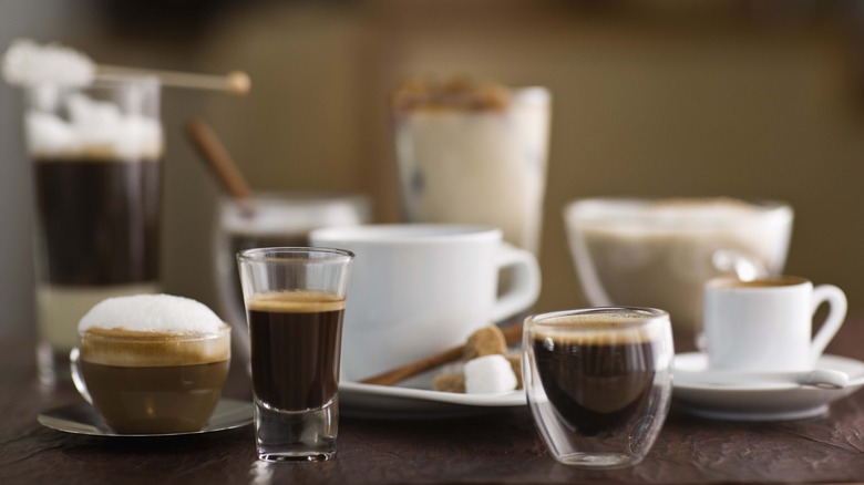 Espresso shots with coffee in the background