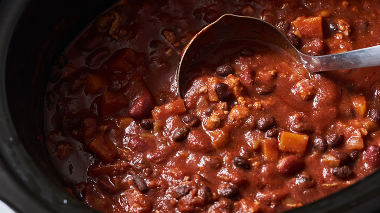 stirring chili in slow cooker