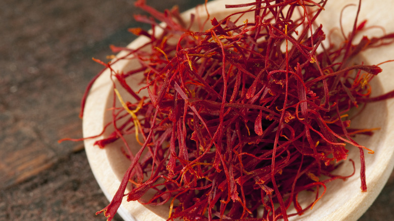 Saffron threads on wooden spoon