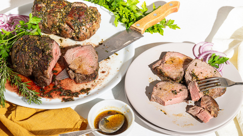 Two plates with sliced herb roasted beef tenderloin