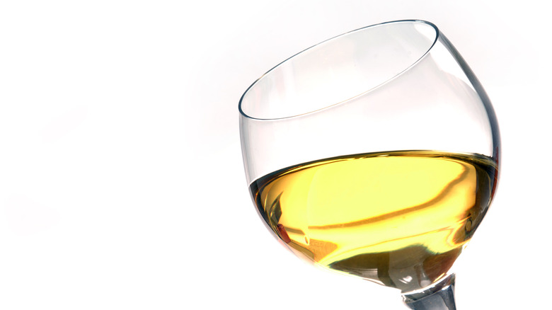 Glass of white wine on white background