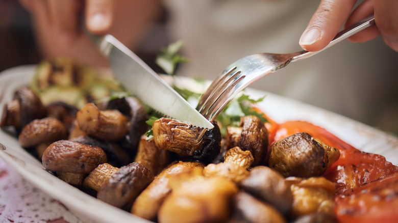 Cutting mushrooms on plate