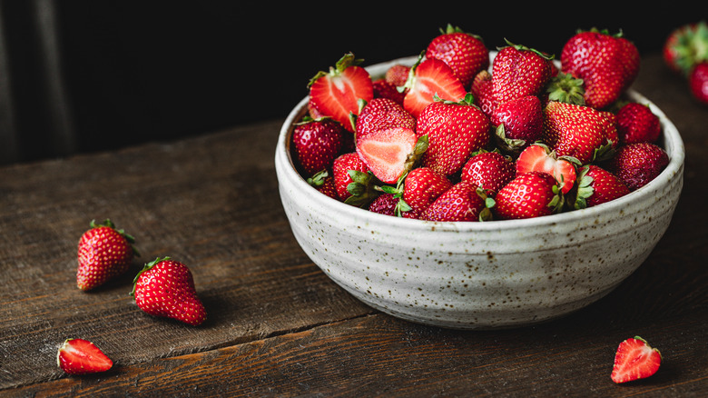 Hands holding basket of strawberries