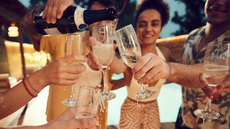 Pouring Champagne into glasses. 