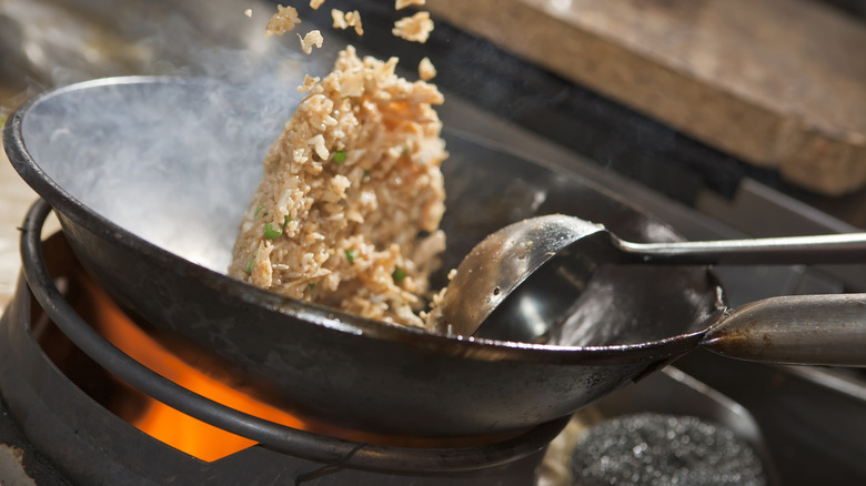 Rice being fried in wok.