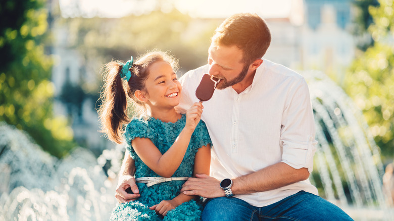 child and dad sharing ice cream