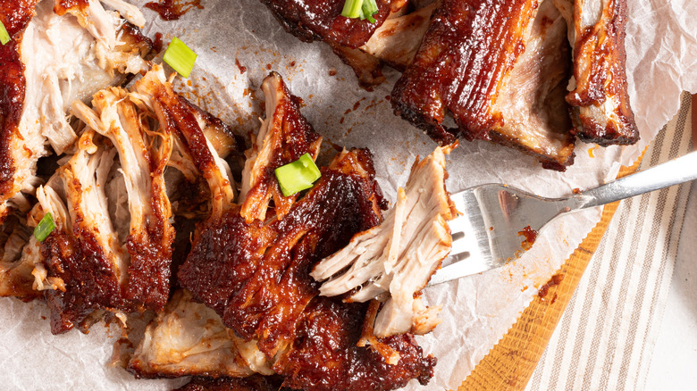 BBQ baby back ribs with a fork and piece of meat