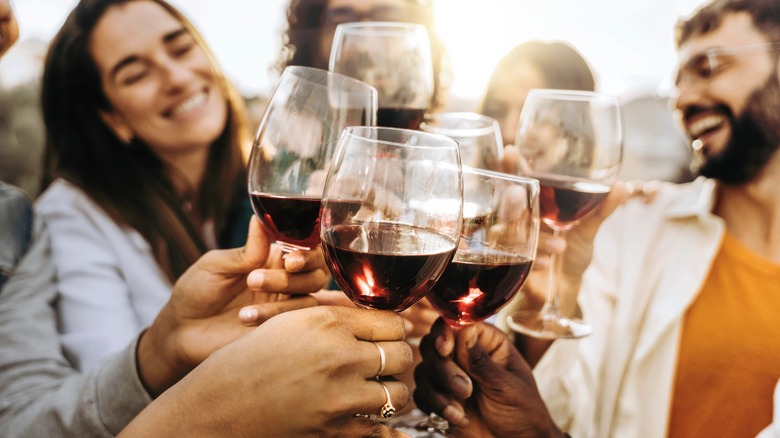 people clinking wine glasses