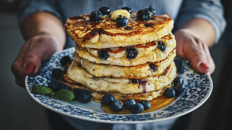 hands holding pancake stack