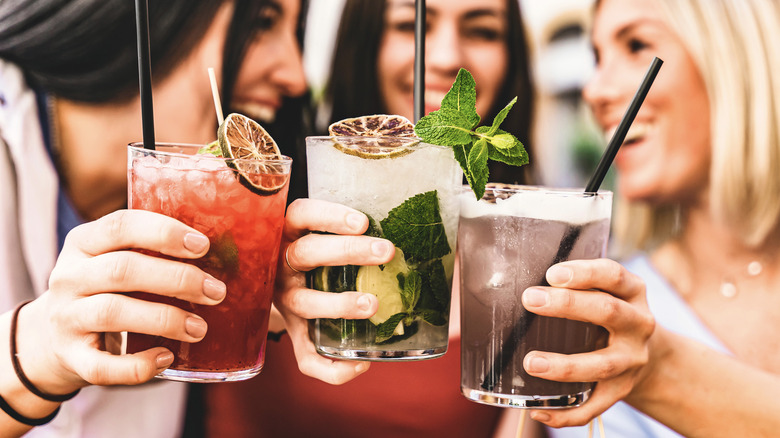 three women holding cocktails