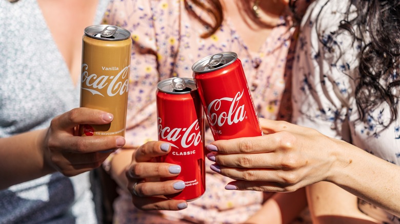 Three friends drinking coke