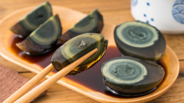 Sliced century egg with chopsticks