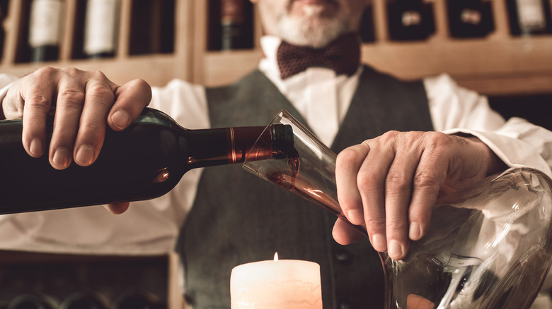 Sommelier with a candle and wine bottle