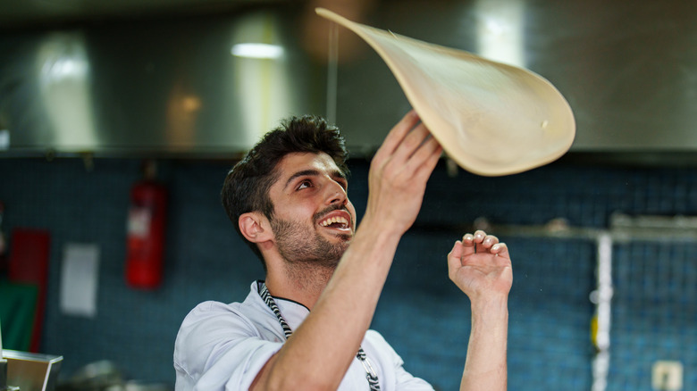 Man tossing pizza dough