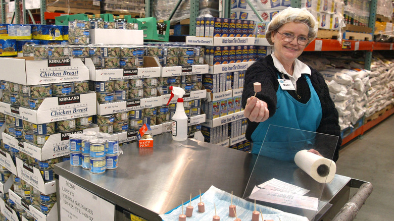 woman handing samples costco