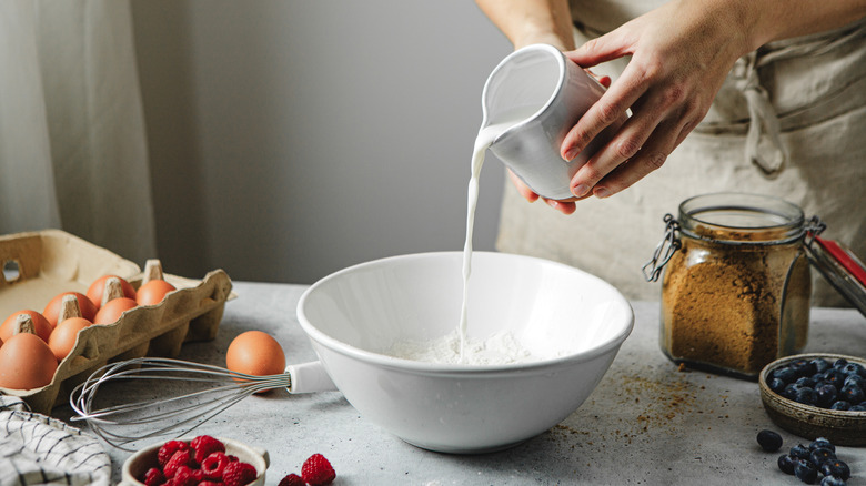 Person pouring milk into bowl