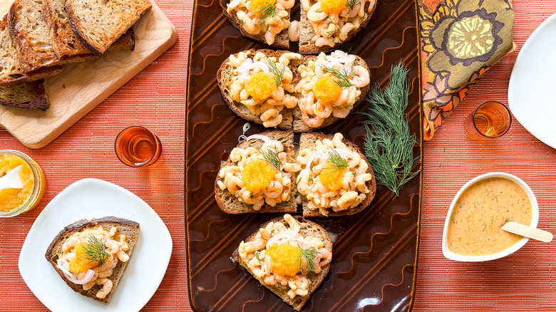 Shrimp salad toast skagen on serving platter with fresh dill