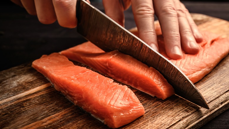 chef slicing raw salmon filet