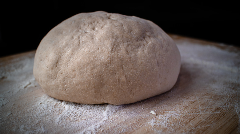 Bread dough on a floured cutting board.  