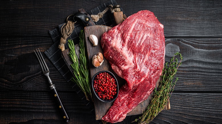 Tri tip steak surrounded by seasonings. 