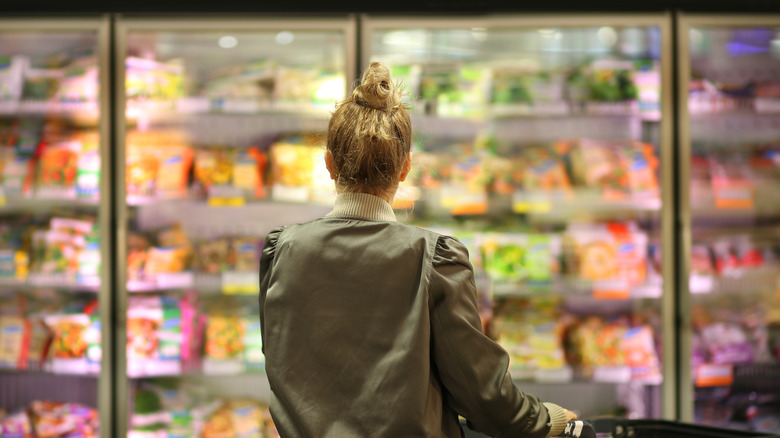 Woman look at frozen dinners