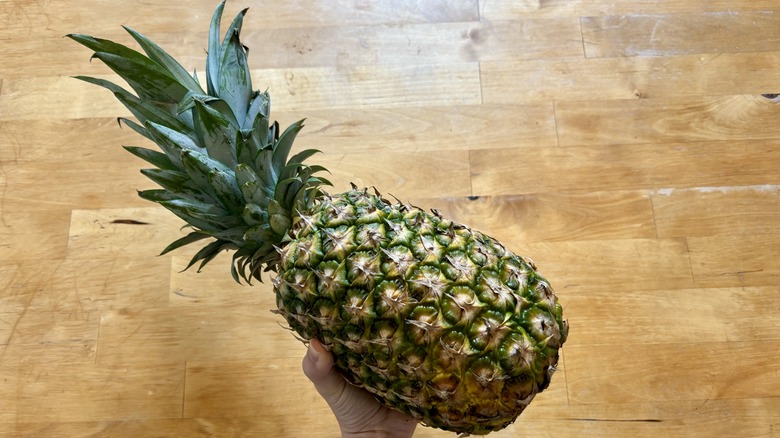 Hand holding pineapple