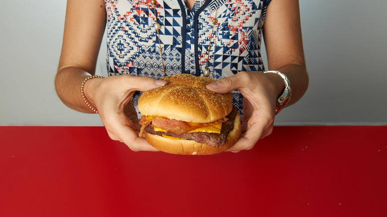 woman holding Wendy's burger