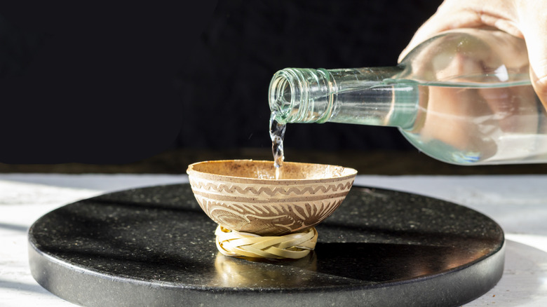 Mezcal poured into jicara 