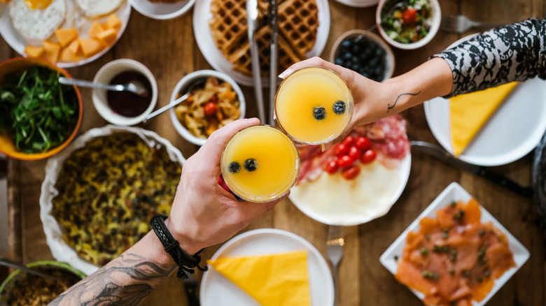 toasting with cocktails over brunch