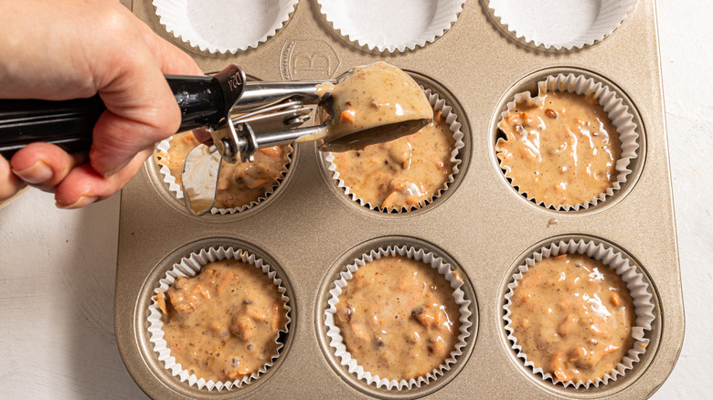 Filling up cupcake paper cups with batter