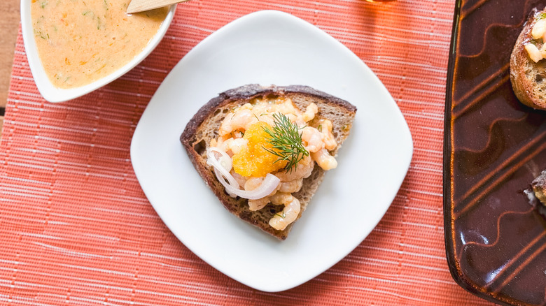 Shrimp salad toast Skagen on plate with extra mayonnaise dressing on side