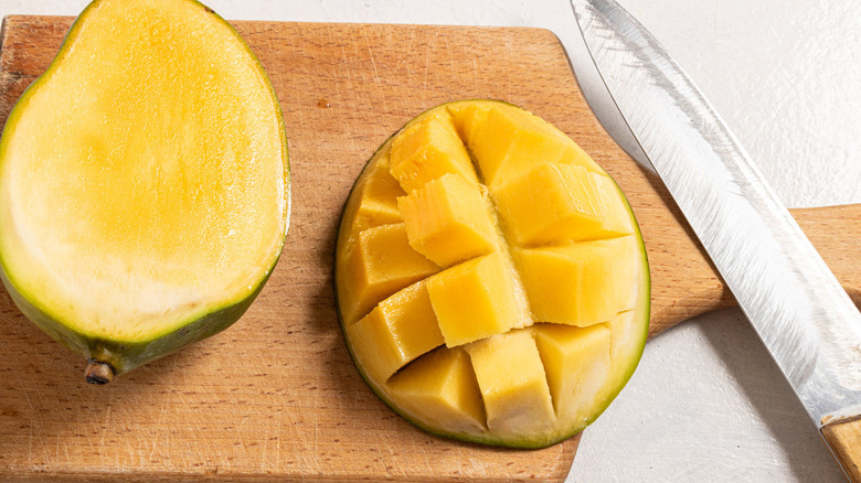 partially chopped mango with knife