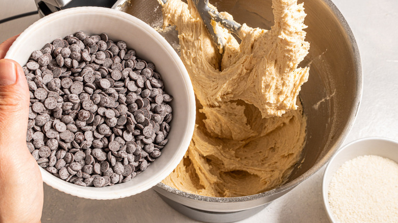 chocolate chips going into cookie dough