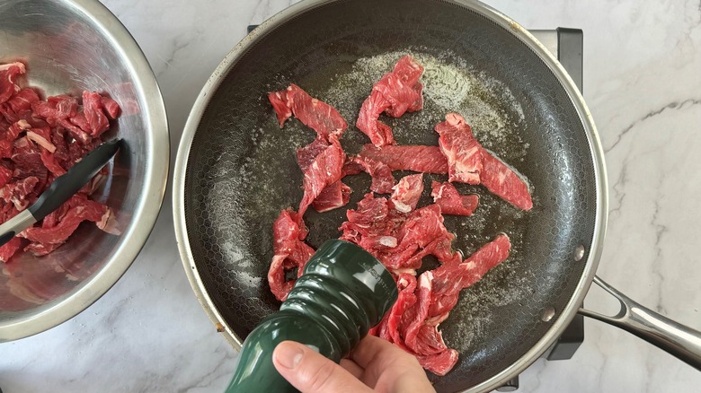 hand holding large pepper grinder