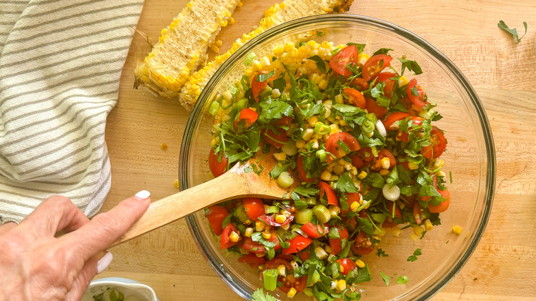 hand stirring the salad