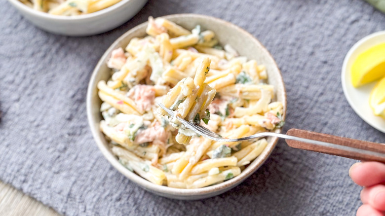 Salmon dill pasta salad in bowl with fork